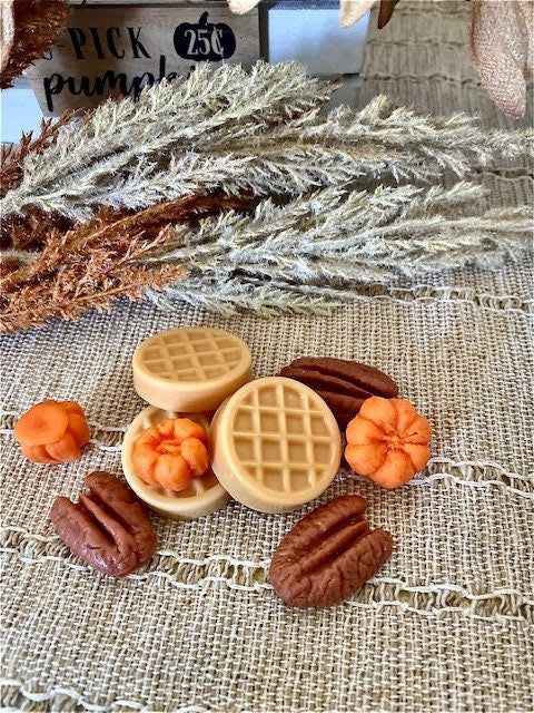 Decorative faux pumpkins and pecans on burlap fabric