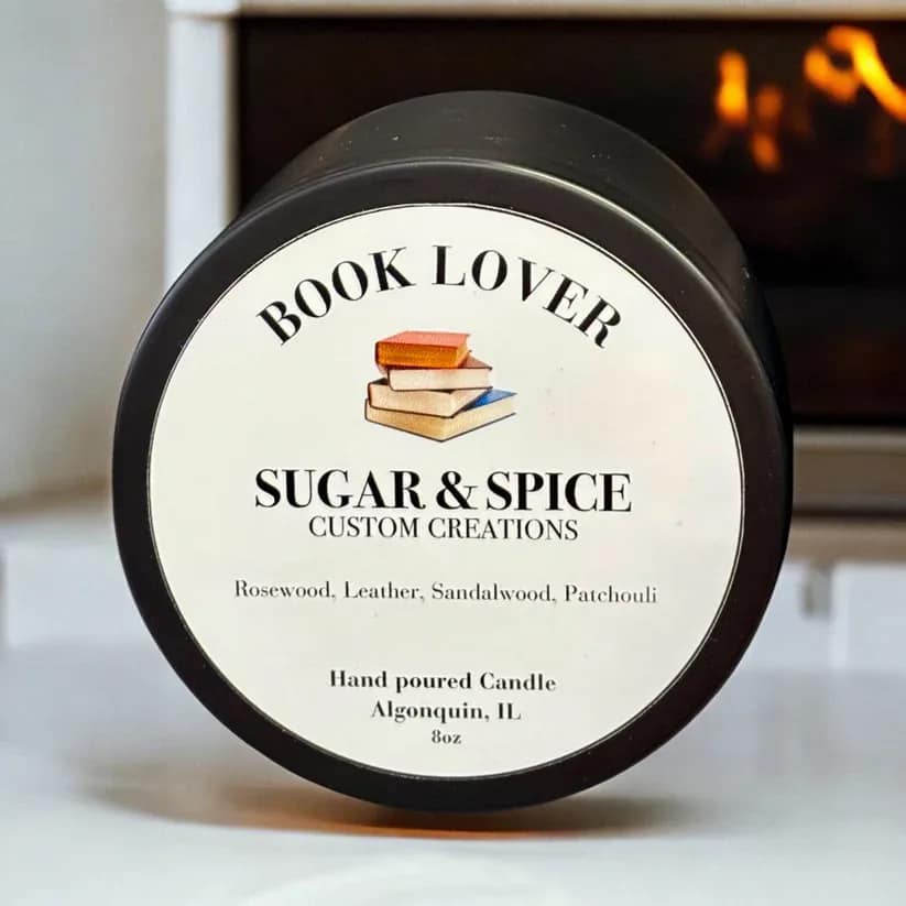 A black-lidded candle jar with a book-themed label.