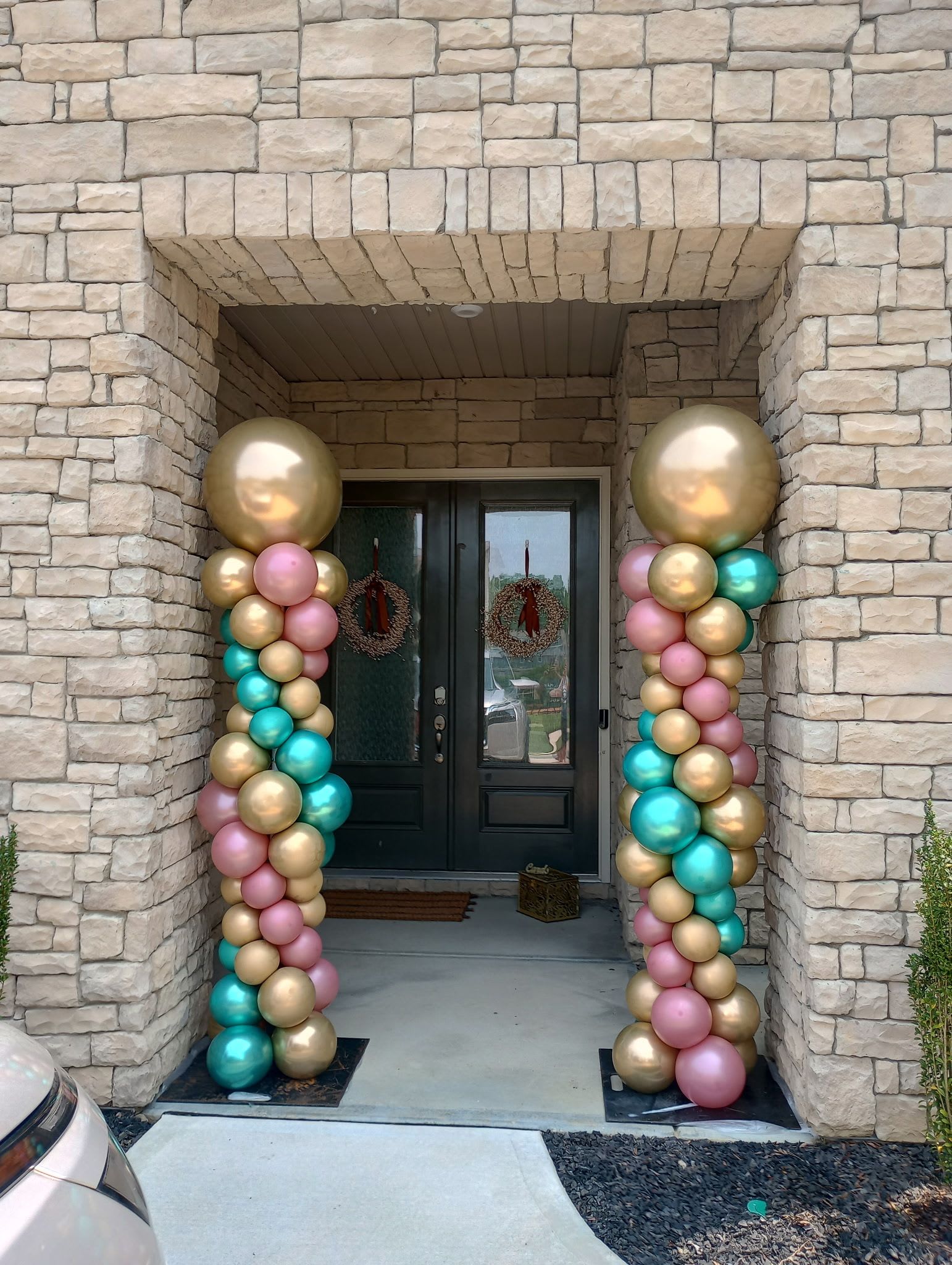 Pastel and metallic balloon columns framing a front door