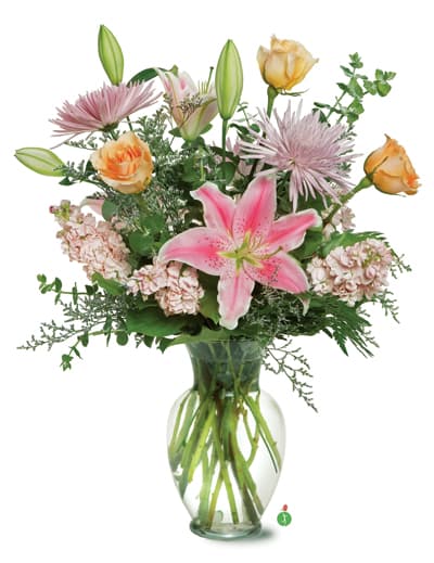 Pink lilies and roses arranged in a clear glass vase