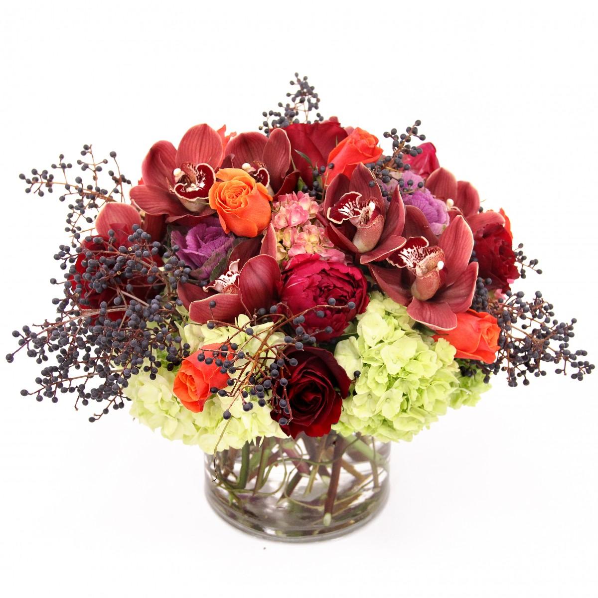 This Elegant Autumn arrangement. -  One of the happiest times of the year is nearly upon us with Thanksgiving right around the corner. Celebrate with your family, friends, and loved ones gathered at the dinner table, and do it with a beautiful floral arrangement at the cente,short cylinder vase filled with rich colored flowers including deep red roses, burgundy cybidium orchids, deepurgund peonies (seasonal), green hydrangea, orange roses and privet berries