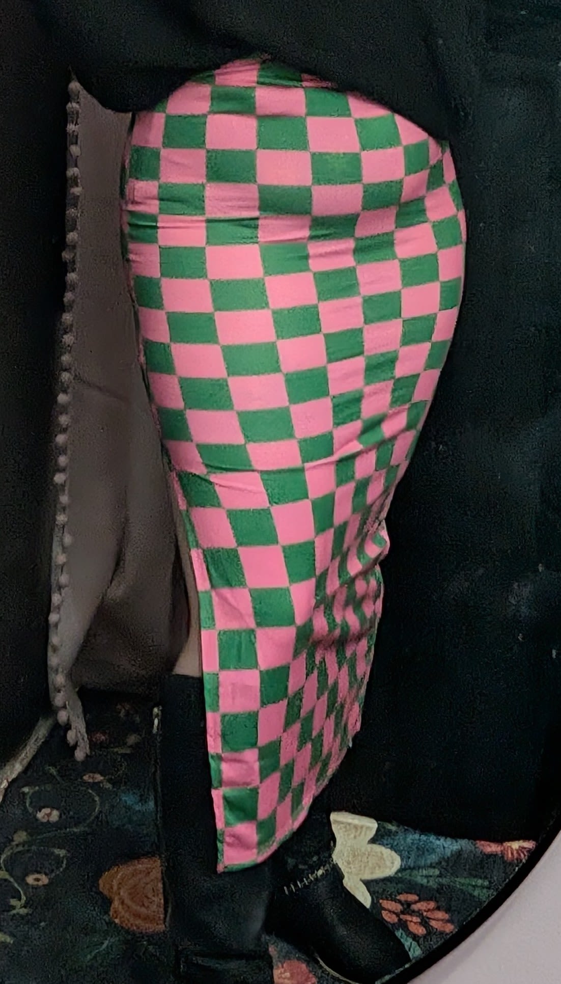 Pink and green checkered fabric draped over a dark object