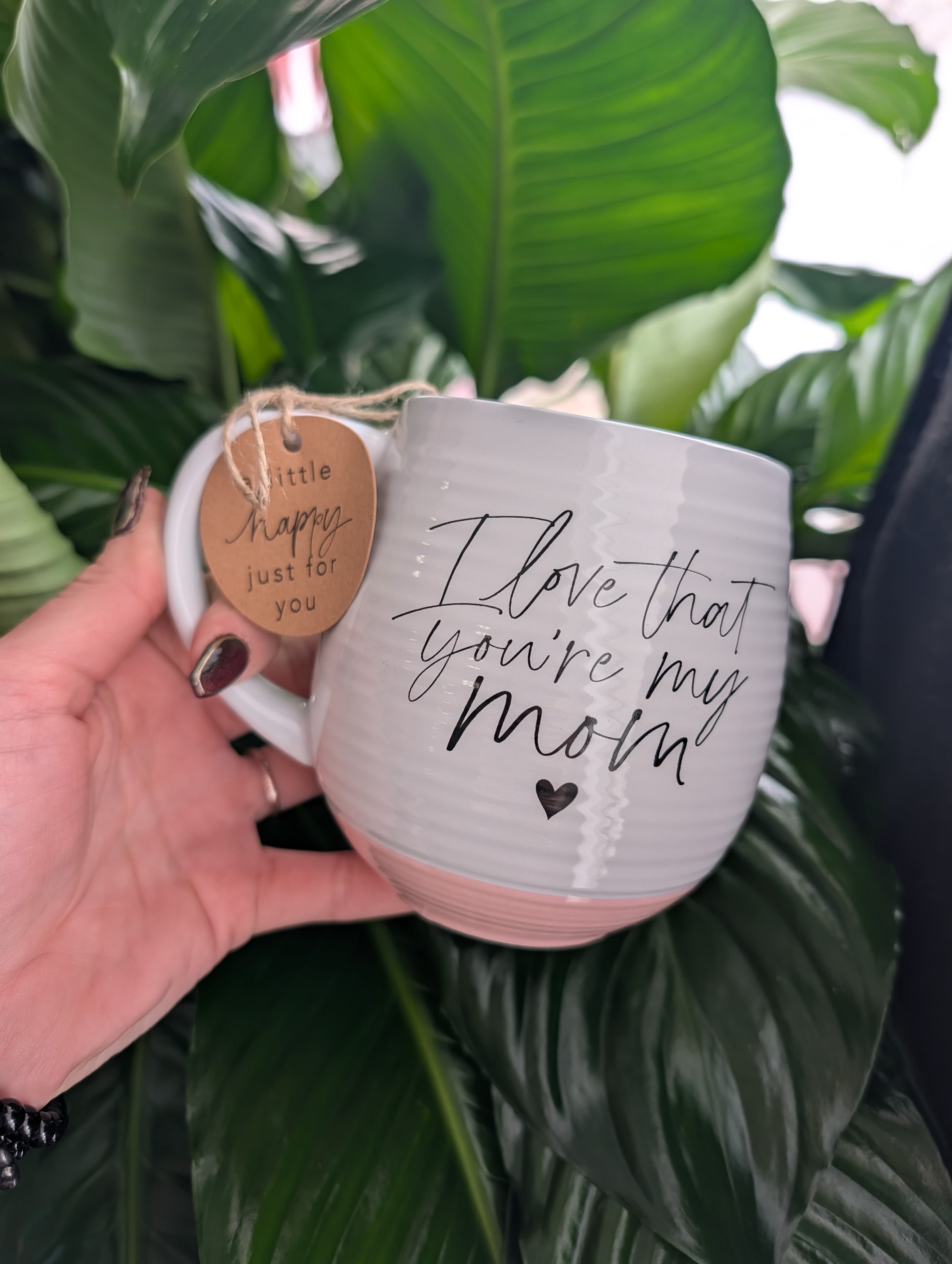 White mug with "I love that you're my mom" text and a hanging tag