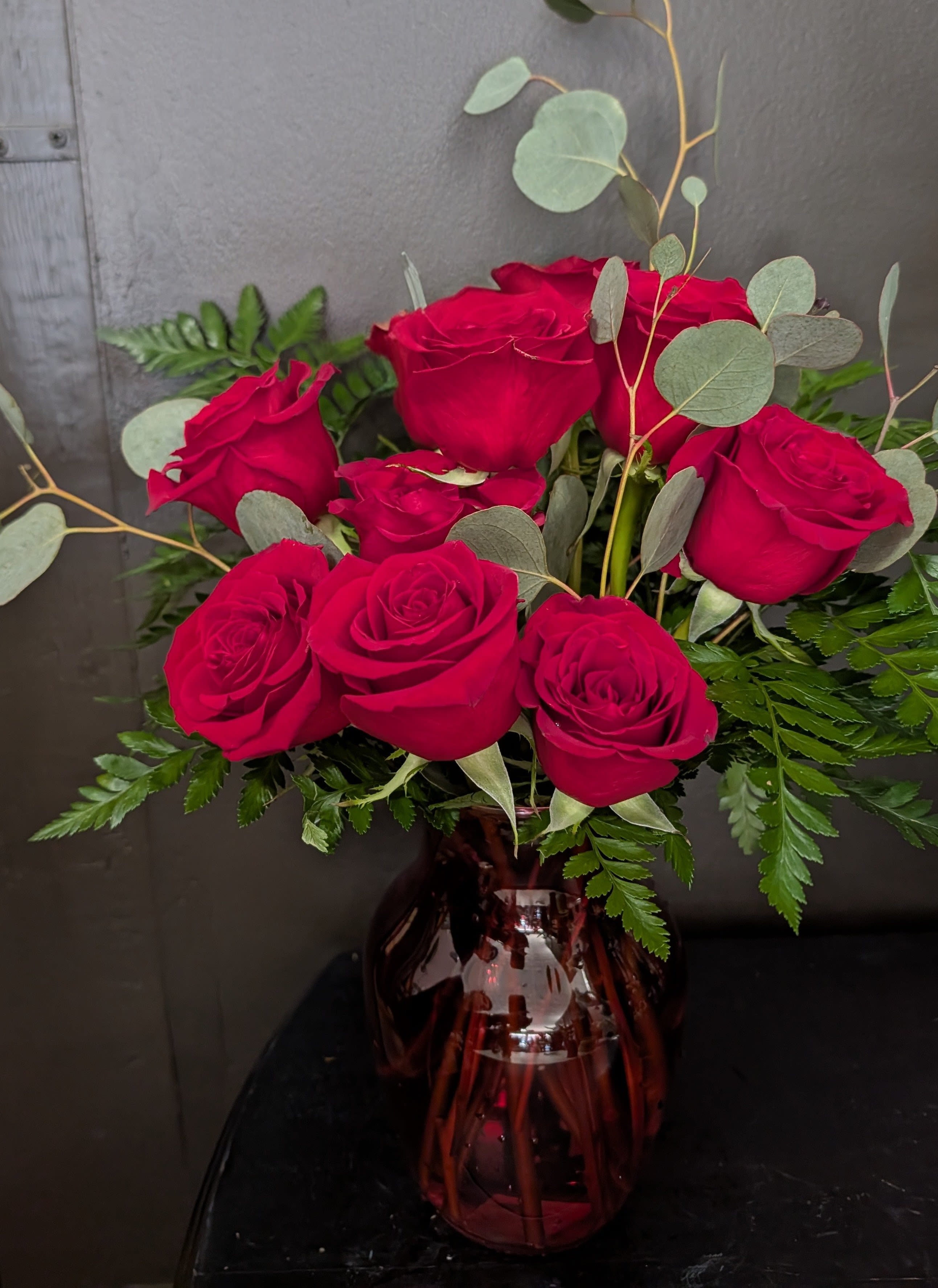 Bouquet of red roses in a burgundy glass vase