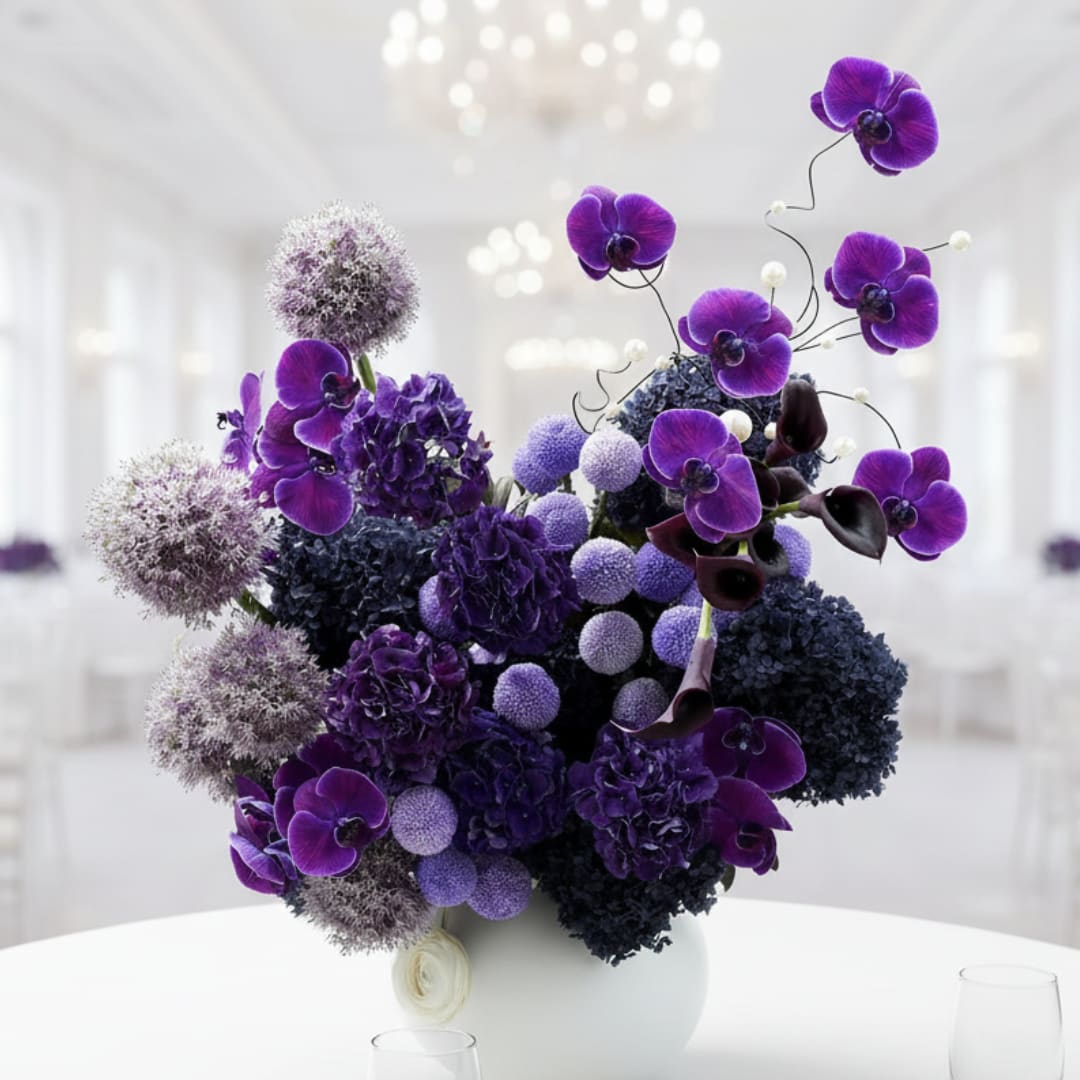 Purple orchid arrangement in a white vase