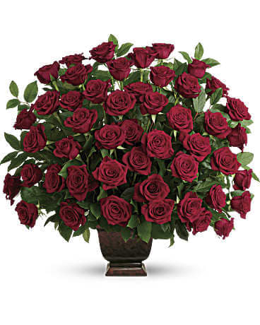 Large bouquet of deep red roses in a dark vase