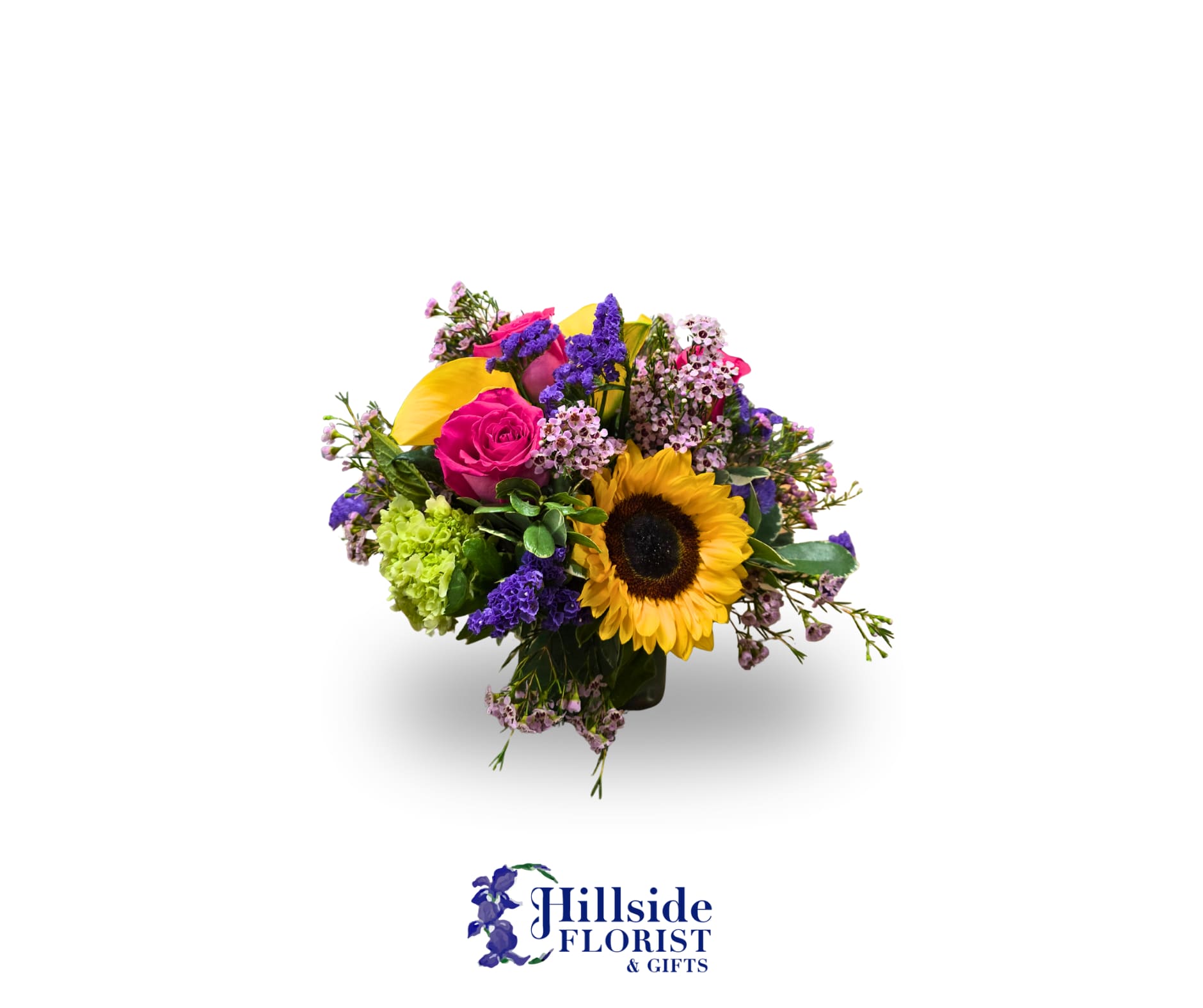 Colorful mixed bouquet with sunflower, pink rose, and purple accents in a glass vase