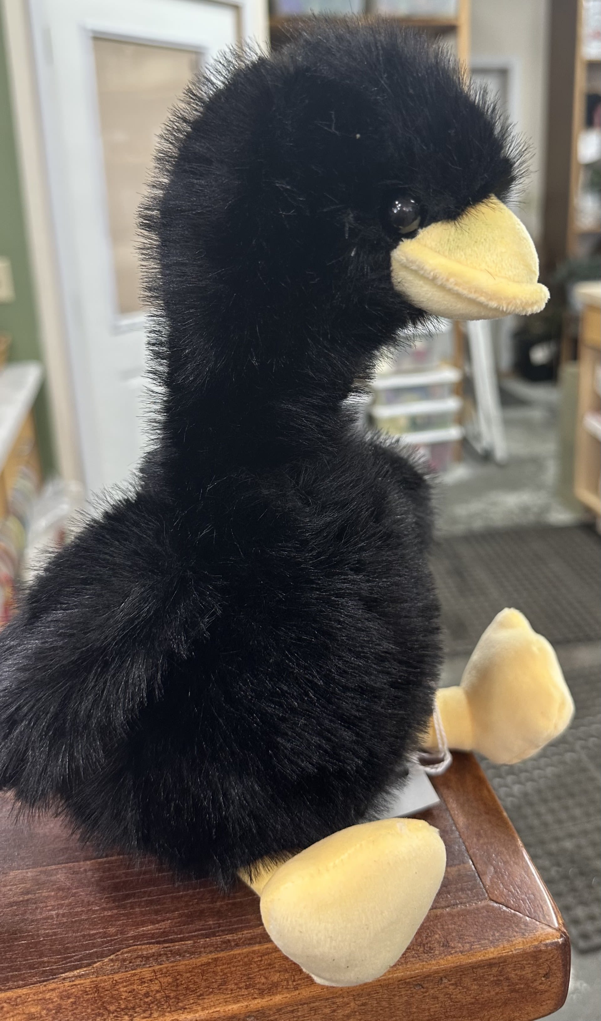 Black plush duck with a yellow beak and feet