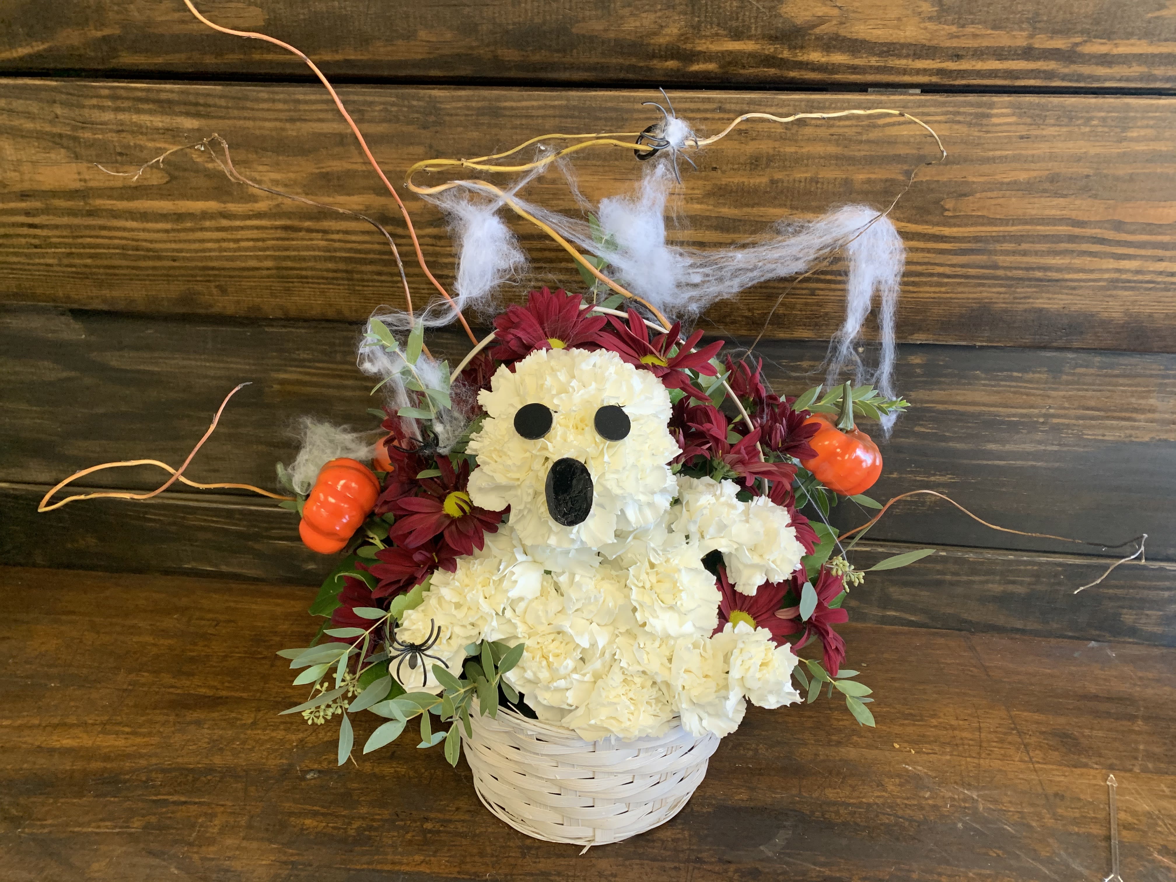 PV Friendly Ghost - Meet our cute Halloween Ghost! They are ready to say happy halloween to your nearest and dearest.  Basket container, Pumpkin colors and florals may vary depending on availability. Shown is a standard arrangement,  deluxe adds more flowers to the same basket for a fuller look. Premium is a bigger basket and more flowers. 