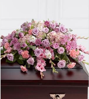 The FTD® Immorata™ Casket Spray - The FTD® Immorata™ Casket Spray offers soft beauty and blushing comfort to honor the life of the deceased. Lavender roses, chrysanthemums and parrot tulips are elegantly arranged amongst pink carnations, gladiolus, stock, hydrangea and lush greens to create a presentation, intended to bedeck the top of the casket, that evokes sweet memories of your loved one for their final farewell service. Approximately 38"W x 28"D. Your purchase includes a complimentary personalized gift message.