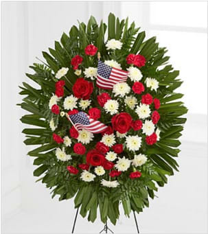 The FTD® Soldier Salute™ Standing Spray - The FTD® Soldier's Salute™ Standing Spray is a gorgeous tribute to a life that was lived with honor and service for our country. Red roses and mini carnations are offset by white chrysanthemums and lush greens beautifully arranged in an oval design and accented with American Flags. Standing on a 48-inch wire easel, this standing spray will bring color and light to their final ceremony. Your purchase includes a complimentary personalized gift message
