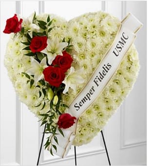 Salute to a Patriot Standing Heart - The FTD® Salute to a Patriot™ Standing Heart is the perfect tribute to a fallen marine. A pearly white heart consisting of chrysanthemums is accented with an arrangement of red roses, white Asiatic lilies and lush greens, as well as a white banner that reads, "Semper Fidelis USMC", to create an incredible presentation at their final memorial service. Displayed on a wire easel. Approximately 24"H x 24"W. Your purchase includes a complimentary personalized gift message.