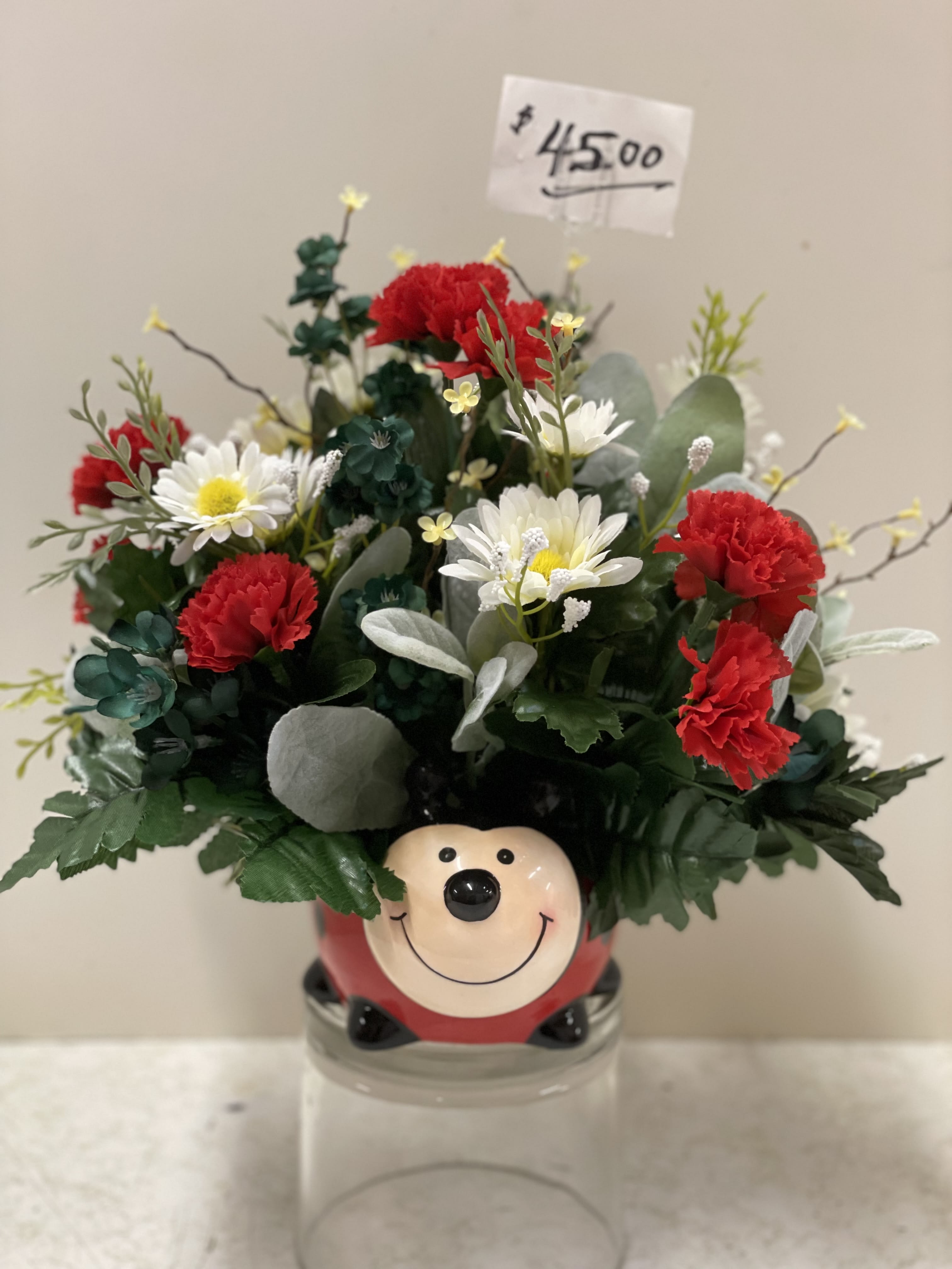 A Bloomin' Lady Bug  - A unique novelty arrangement for those looking for a chance to smile and enjoy their day.  This lush red lady bug ceramic container is filled with a variety of red and white blossoms and assorted greenery and is sure to brighten up anyone's day!  Whether it's a friend who just needs a pick-me-up, a loved one who needs a smile and a get-well wish, or for any other occasion, this novelty is one to keep and recollect for years to come.  