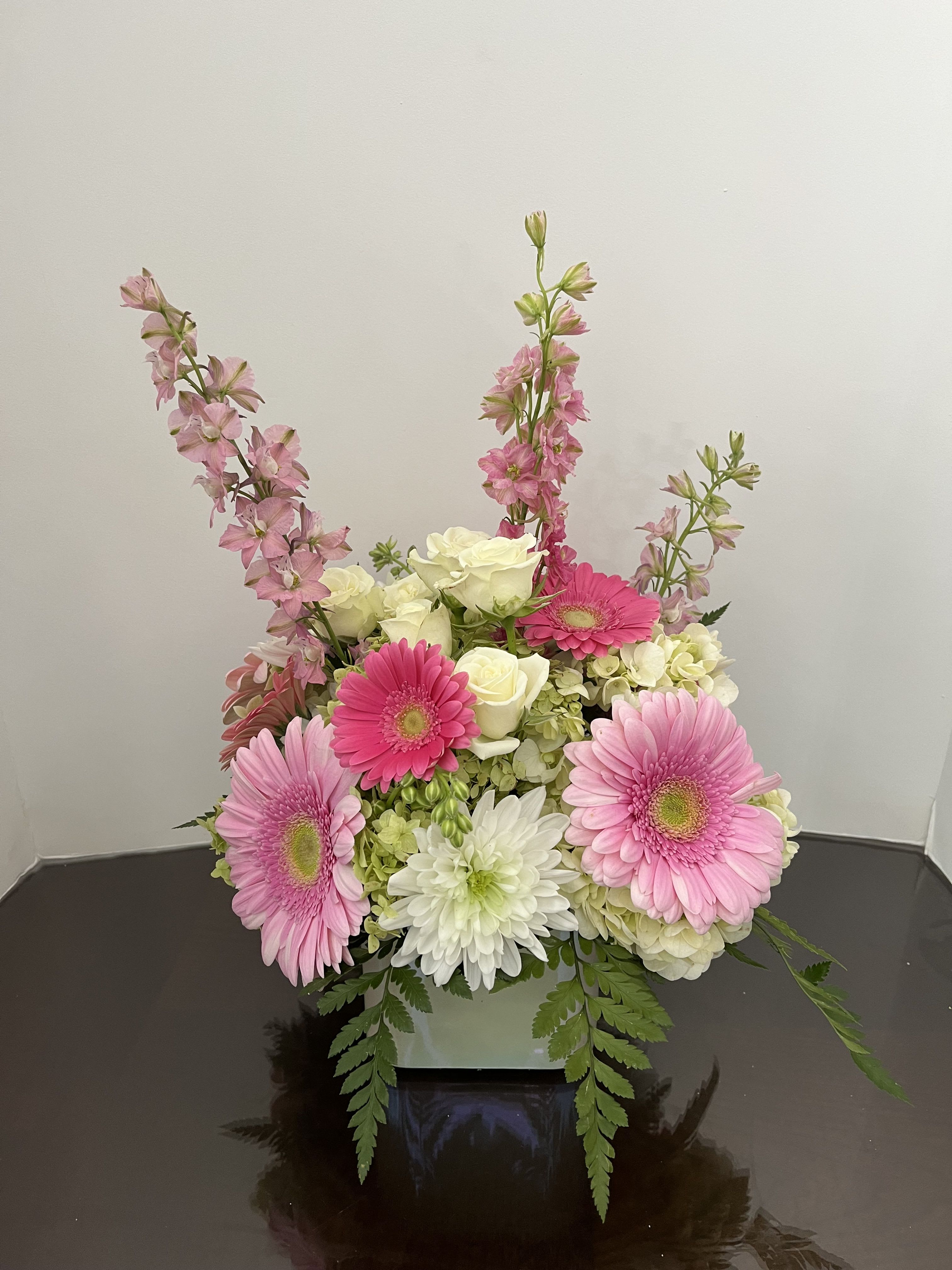Pink gerberas and white roses in a low square vase