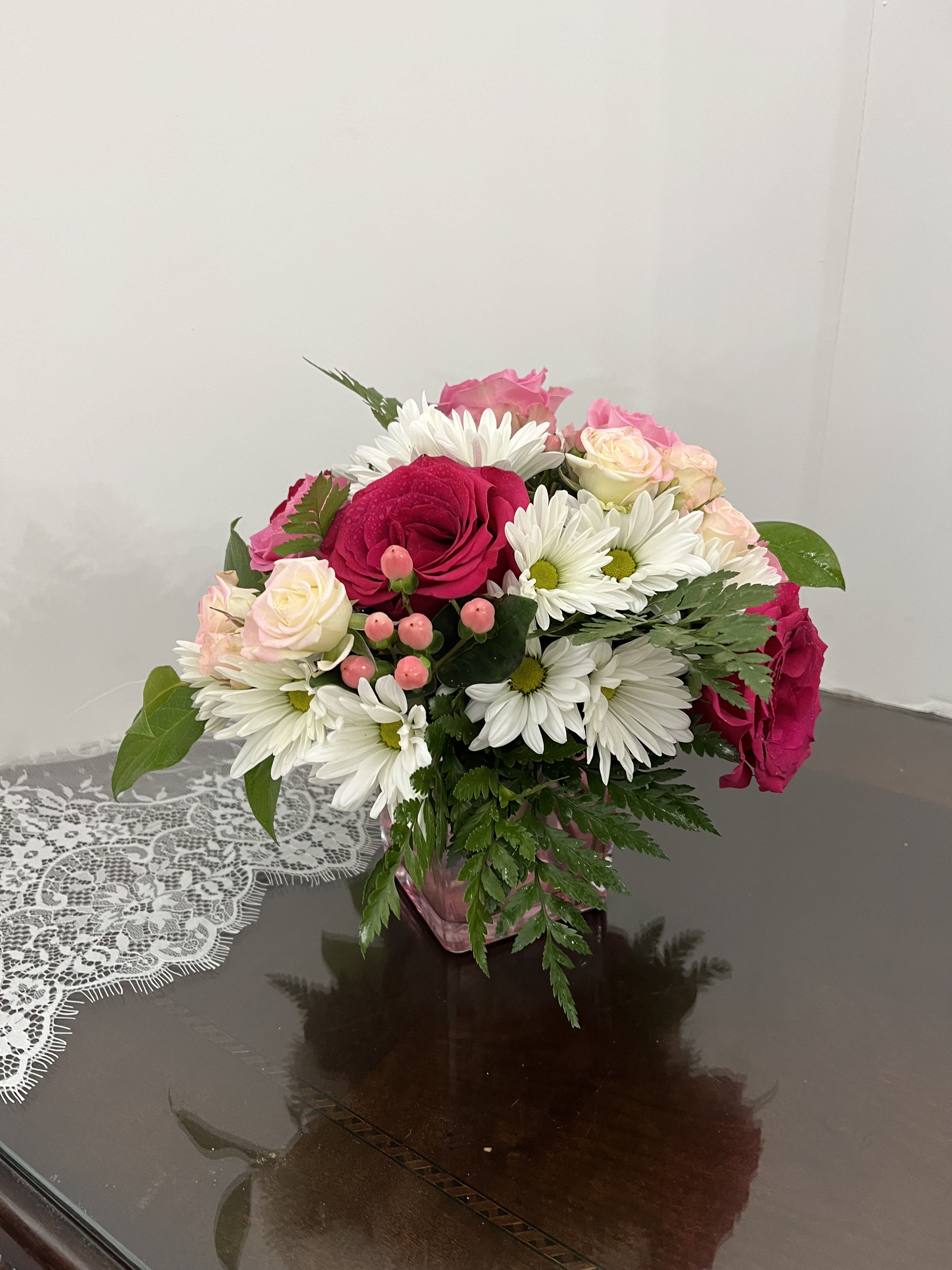 Bouquet of pink and white roses with white daisies in a pink vase