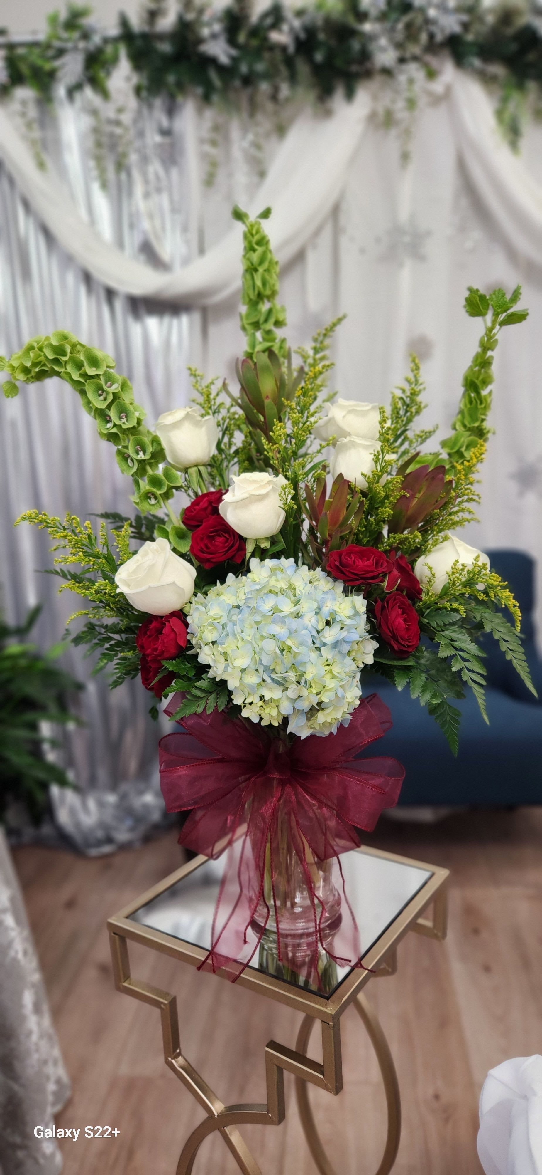 Bouquet of white and red roses with blue hydrangea in a glass vase