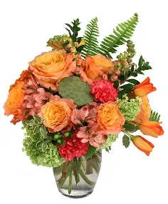 Orange roses and tulips in a glass vase