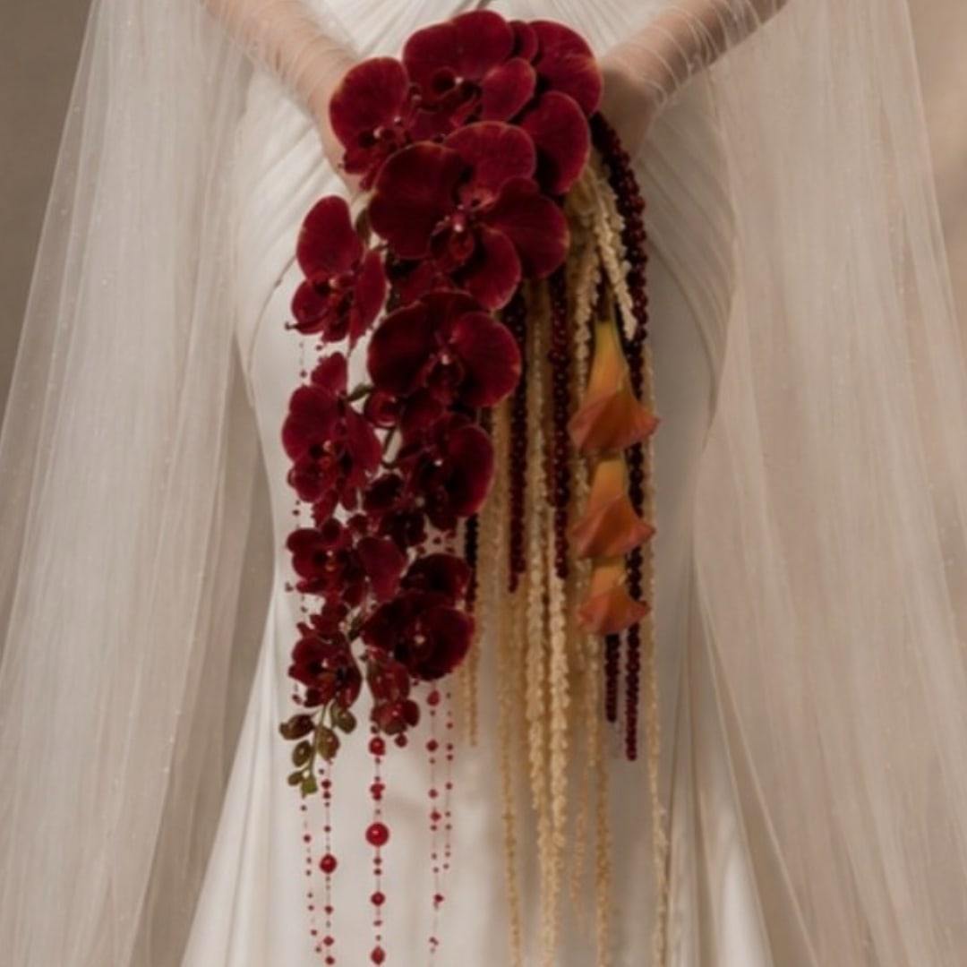 Deep red orchid cascade on white draped fabric