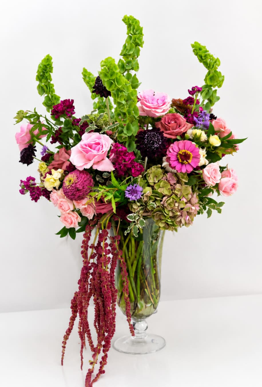 Mixed pink and purple flower arrangement in a glass vase