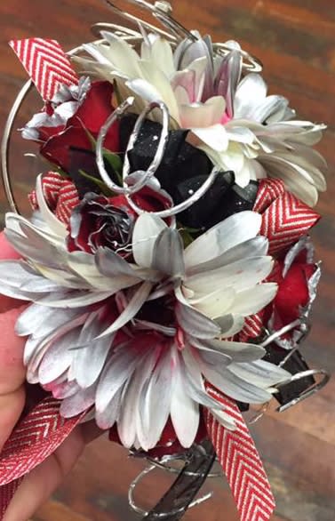 Small bouquet of white daisies and red roses with striped ribbon accents