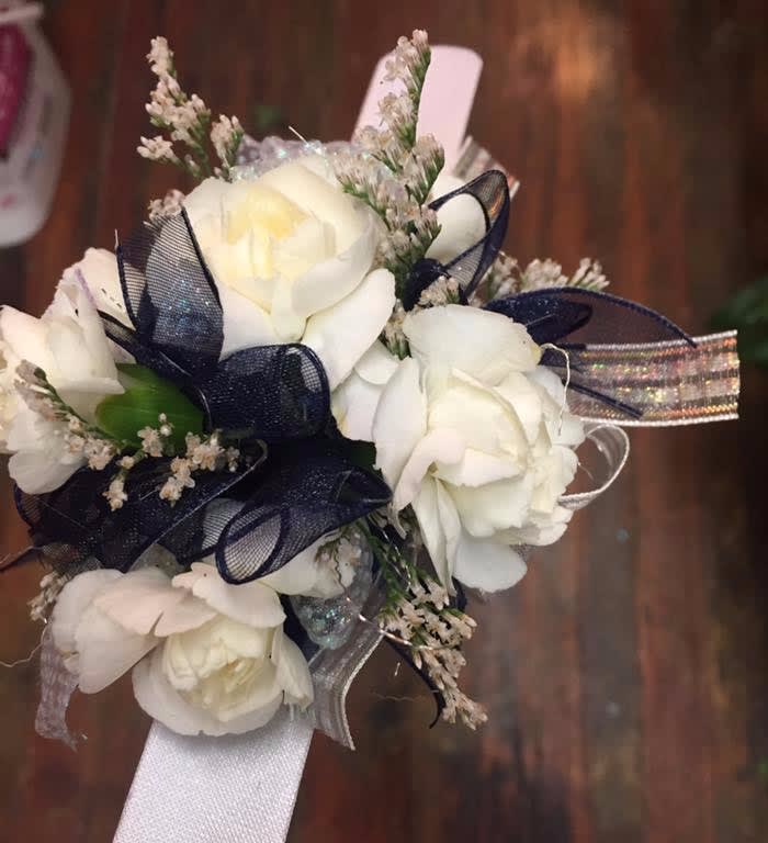 White rose corsage with navy ribbon and silver accents