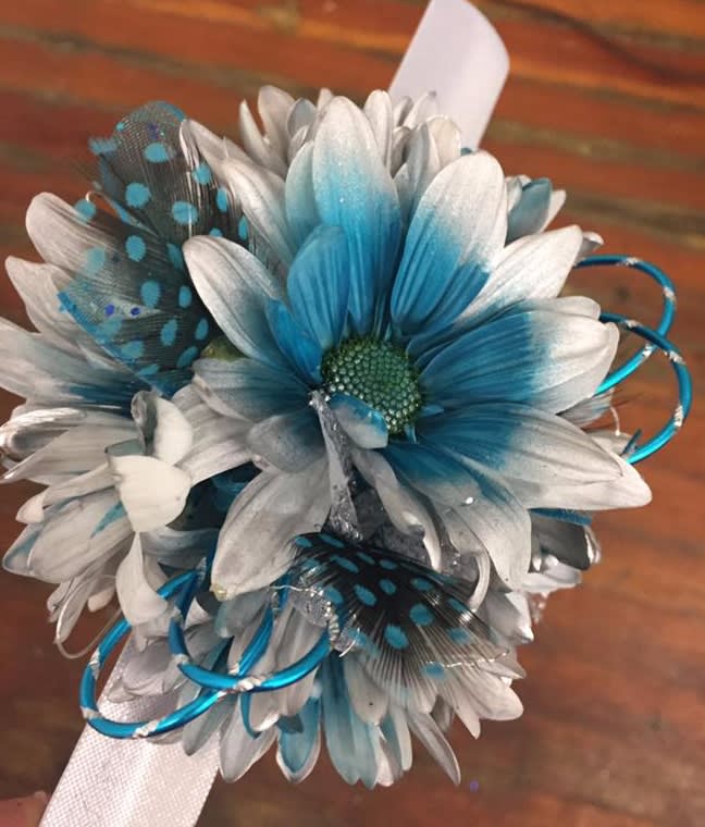 Blue and white daisy bouquet with decorative feathers and ribbon