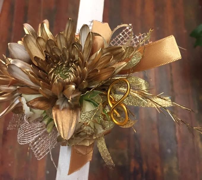 Gold-toned floral corsage with ribbon and mesh accents