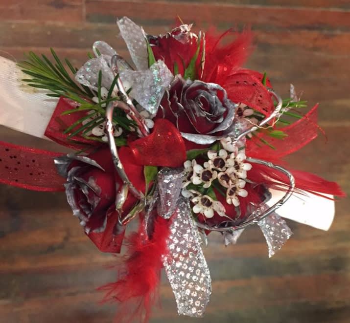 Red and silver floral corsage with ribbon and feathers