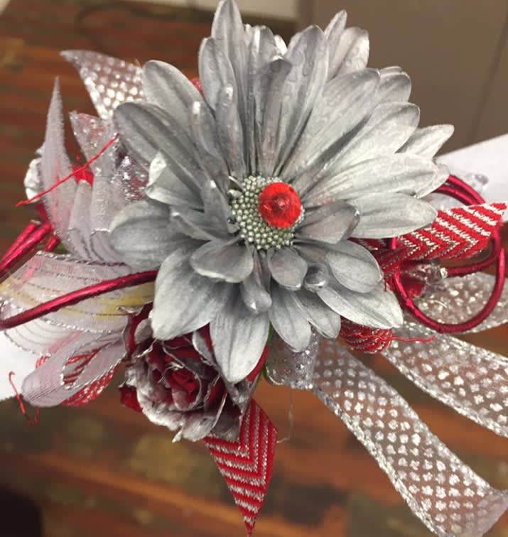 Silver artificial flower corsage with red ribbon accents