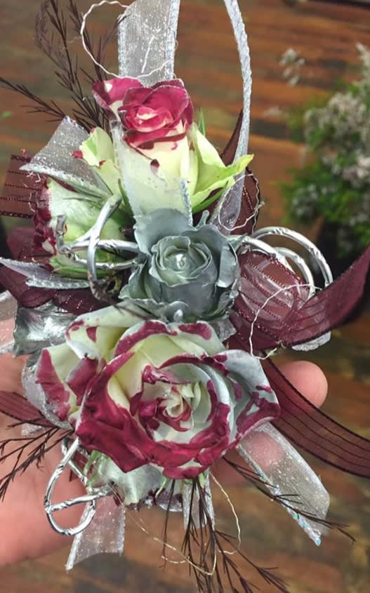 Small hand-held corsage with burgundy and silver roses