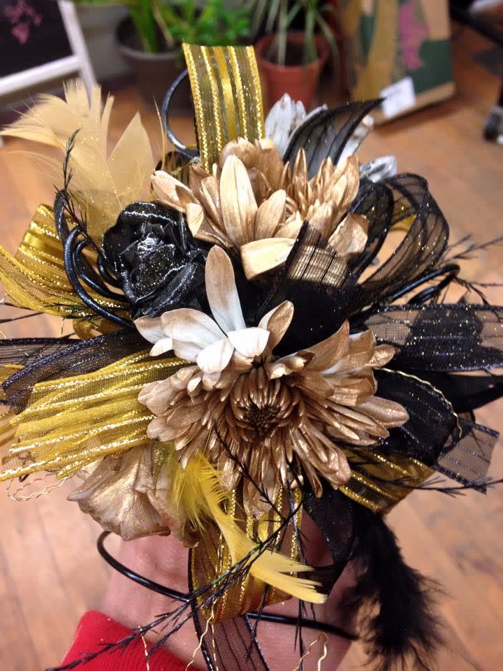 Black, gold, and white floral hair accessory with feathers