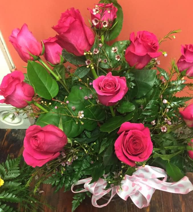Bouquet of hot pink roses with greenery and a pink polka-dot ribbon