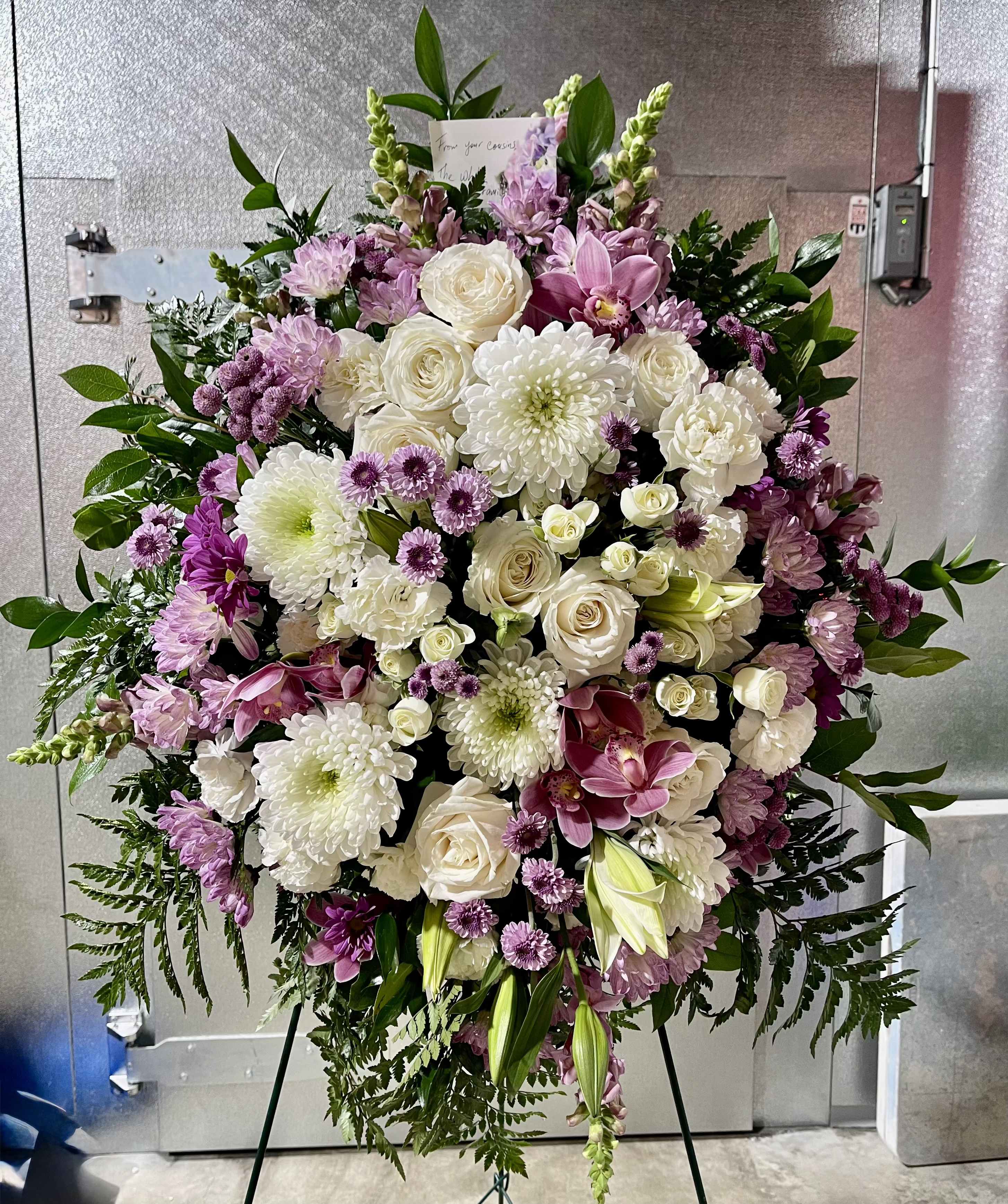 Large standing floral spray with white and pink blooms on an easel