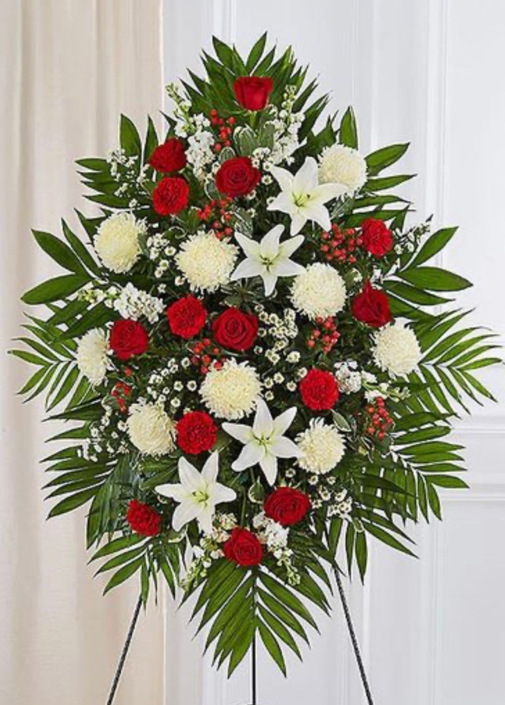 Standing floral spray with red roses, white lilies, and white pompons