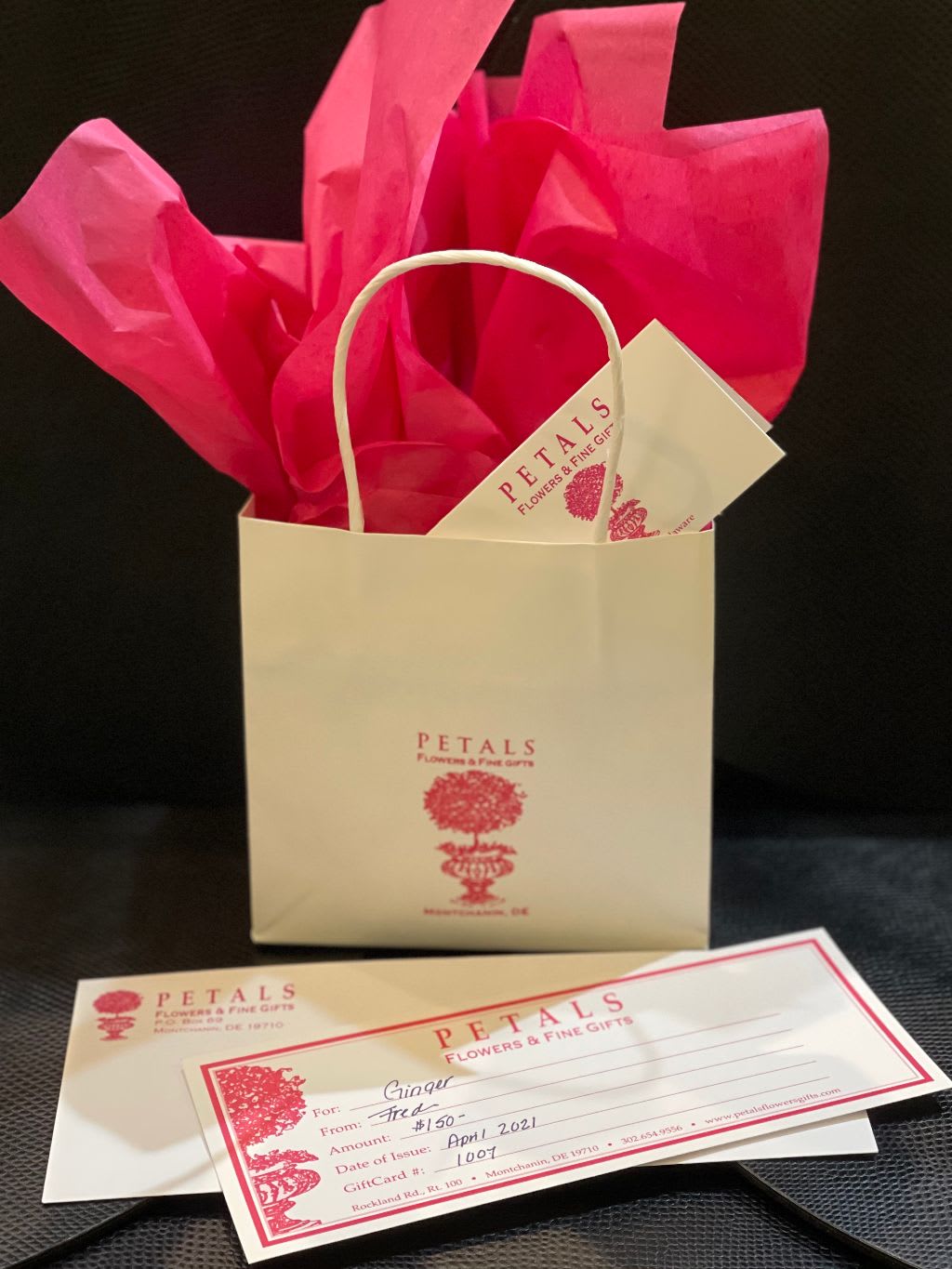 Gift bag with tissue paper and a floral gift card