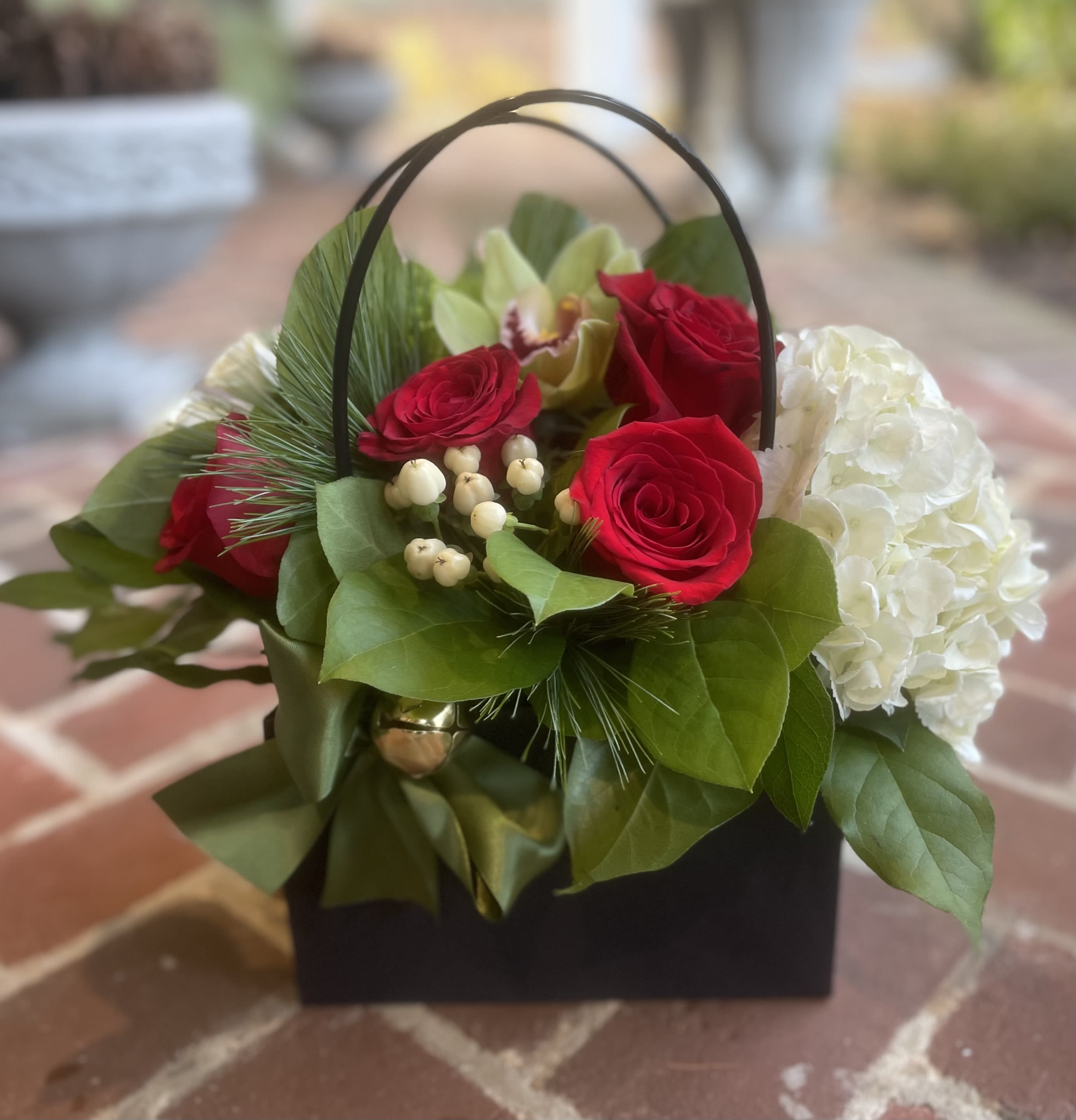 Basket arrangement with red roses and white hydrangea