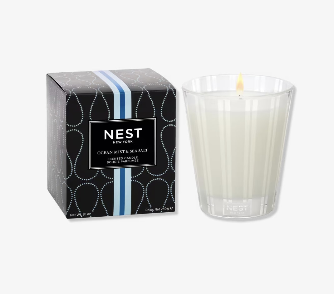Scented candle in a clear glass tumbler beside its box