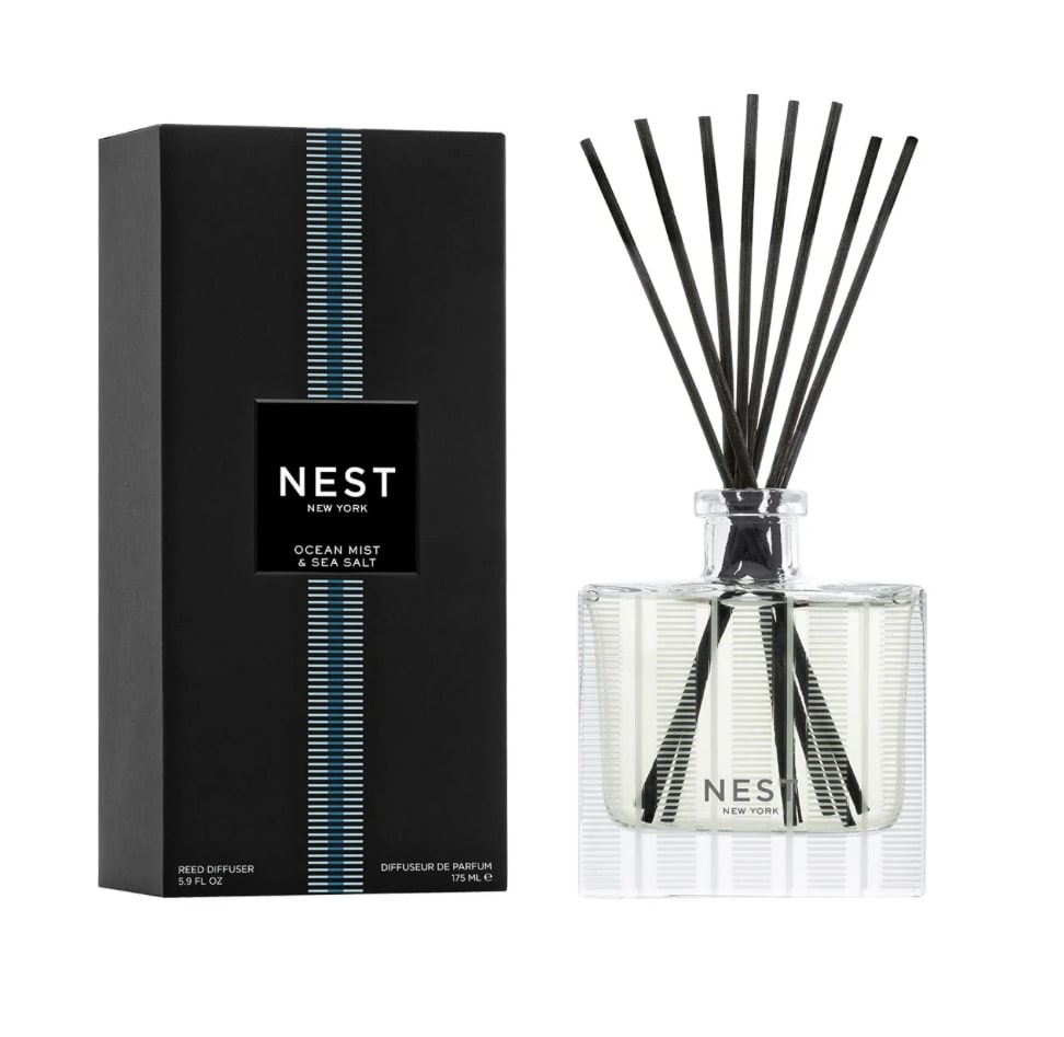 Reed diffuser in a glass bottle with black reeds and a black box