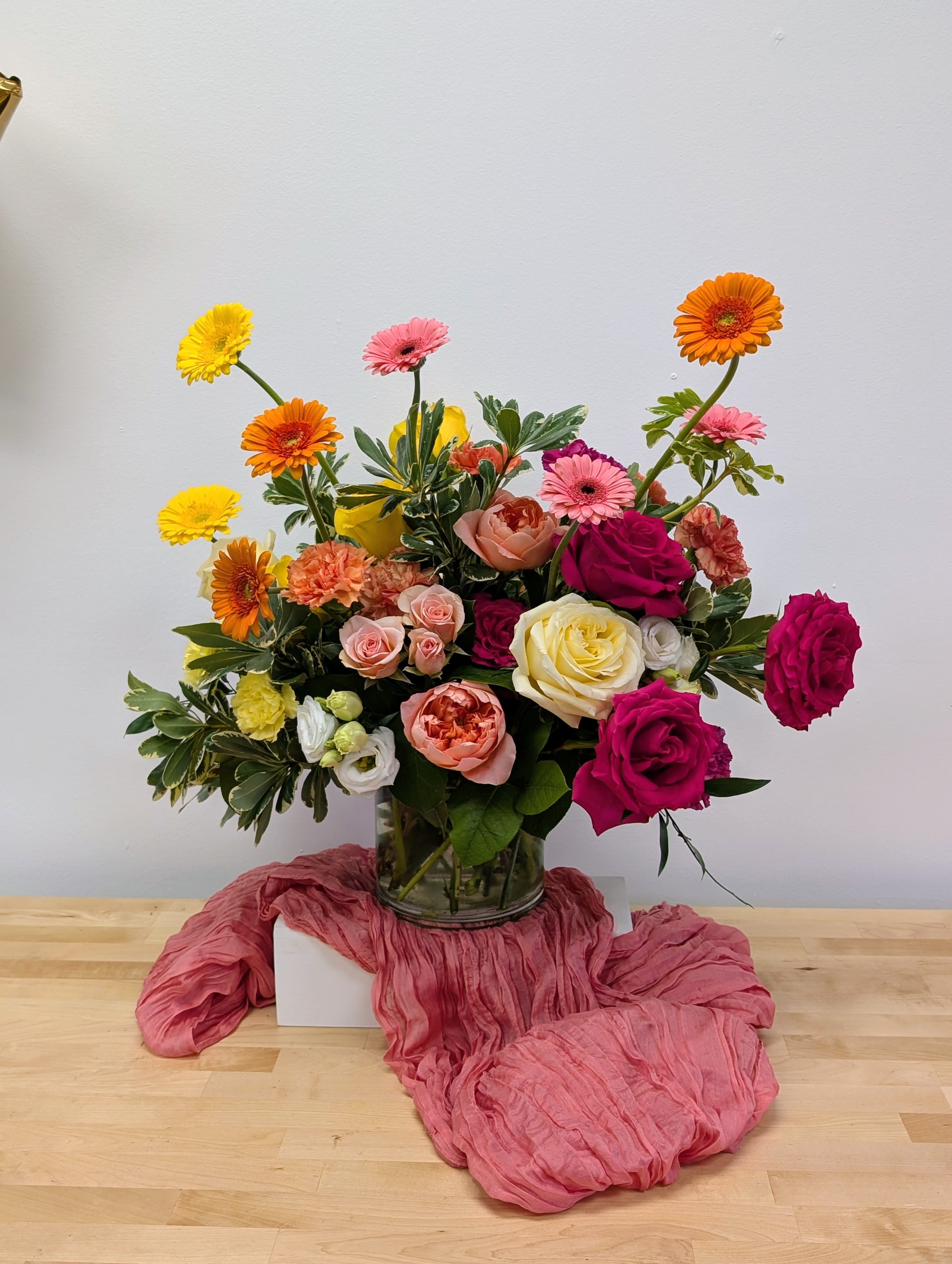 Mixed bouquet of roses and gerbera daisies in a glass vase