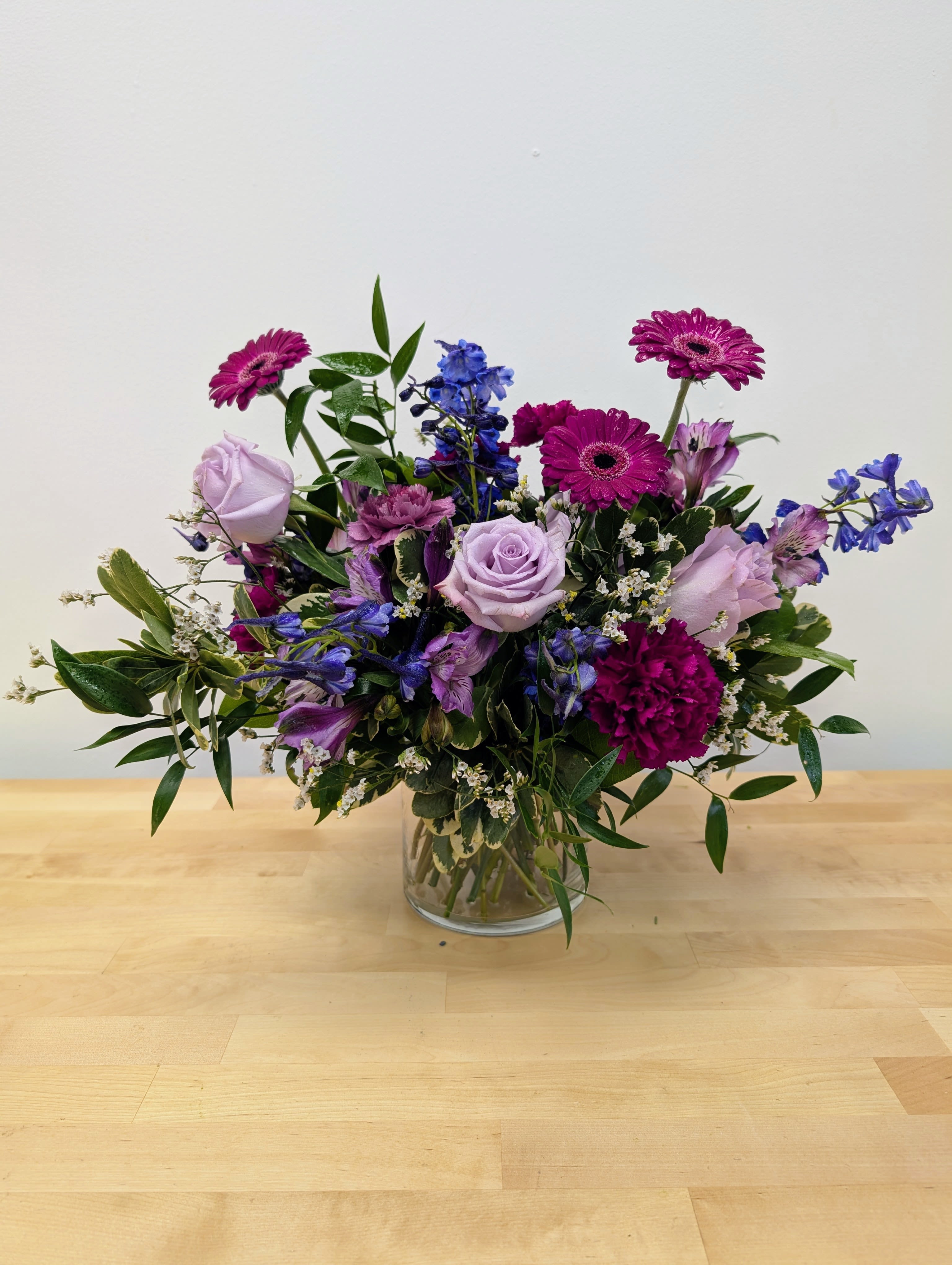 Mixed purple bouquet in a clear glass vase
