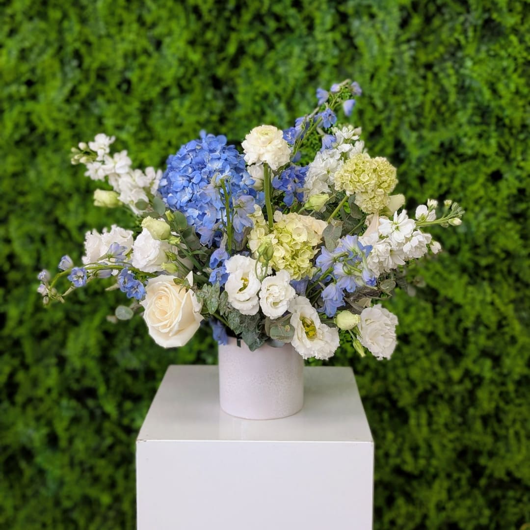 Blue and white flower arrangement in a white vase