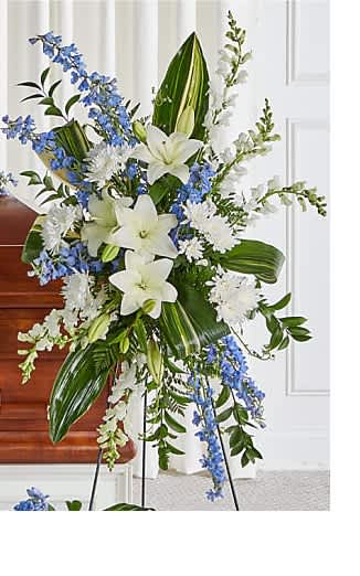 Tall white and blue floral standing spray on an easel