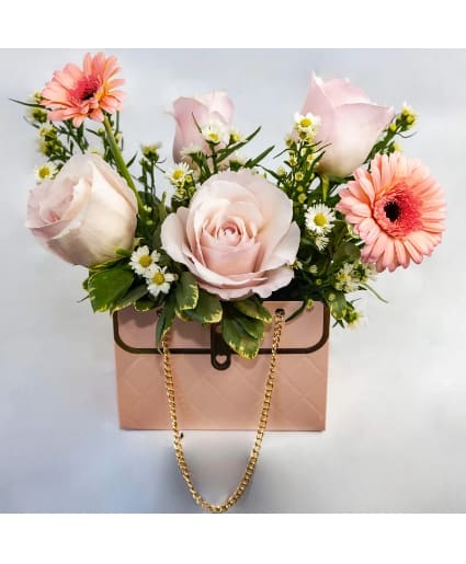 Hello Beautiful Flowers Purse - This vibrant arrangement of  mixed color roses is a delightful representation of joy, beauty, and variety. Each color in the bouquet adds its unique charm, creating a beautiful balance between soft pastels and bold hues.. arrangement of roses, white aster monte casino, and mini gerbera daisy, arranged in a handbag.