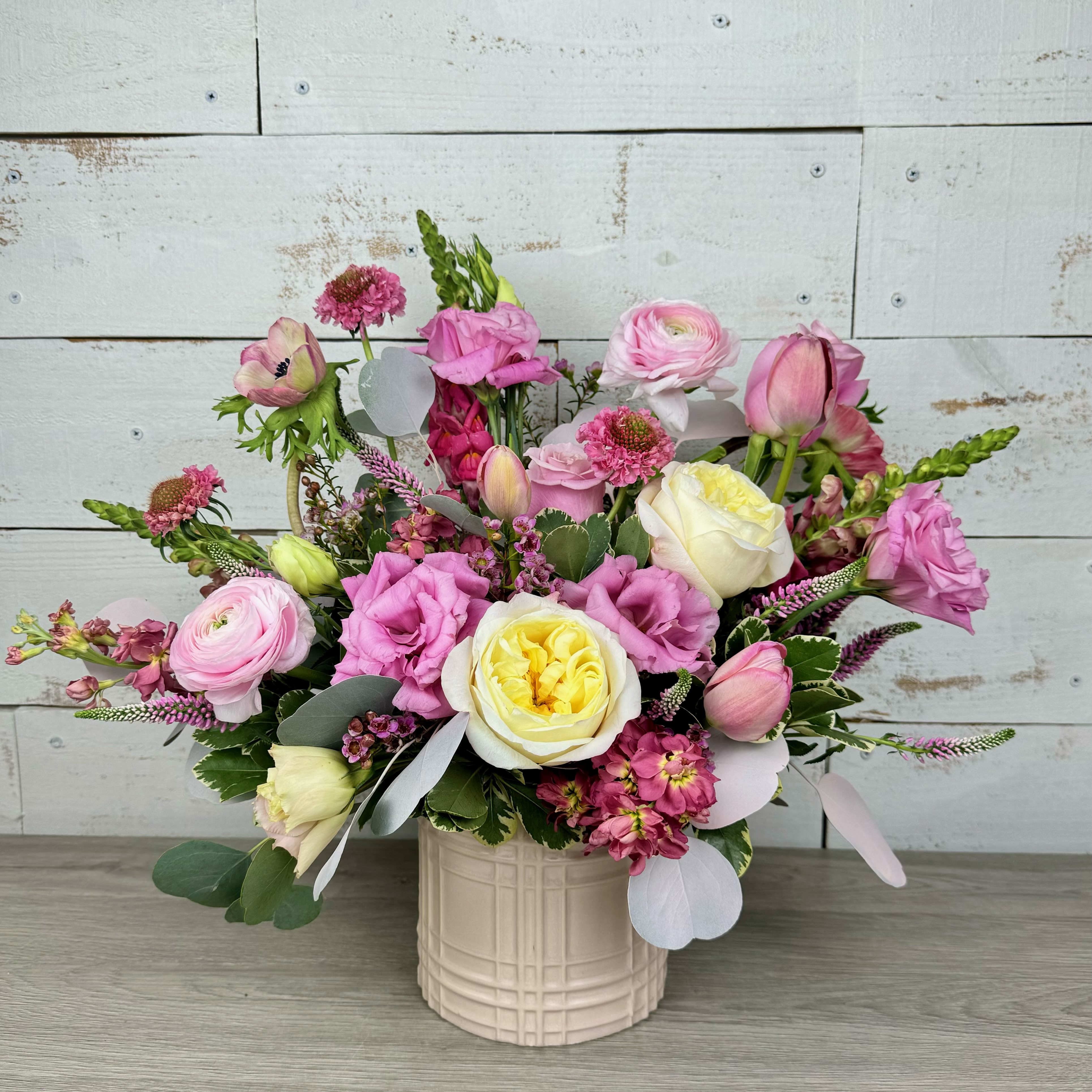 Petal  - Pink, white, yellow garden-style roses, tulips &amp; ranunculus in a light pink ceramic vase.  - romantic, full blooms for birthdays, anniversaries or Mother's Day. Order hand-delivered flowers in San Antonio.