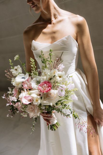 Bride holding a pastel bouquet with white and pink flowers
