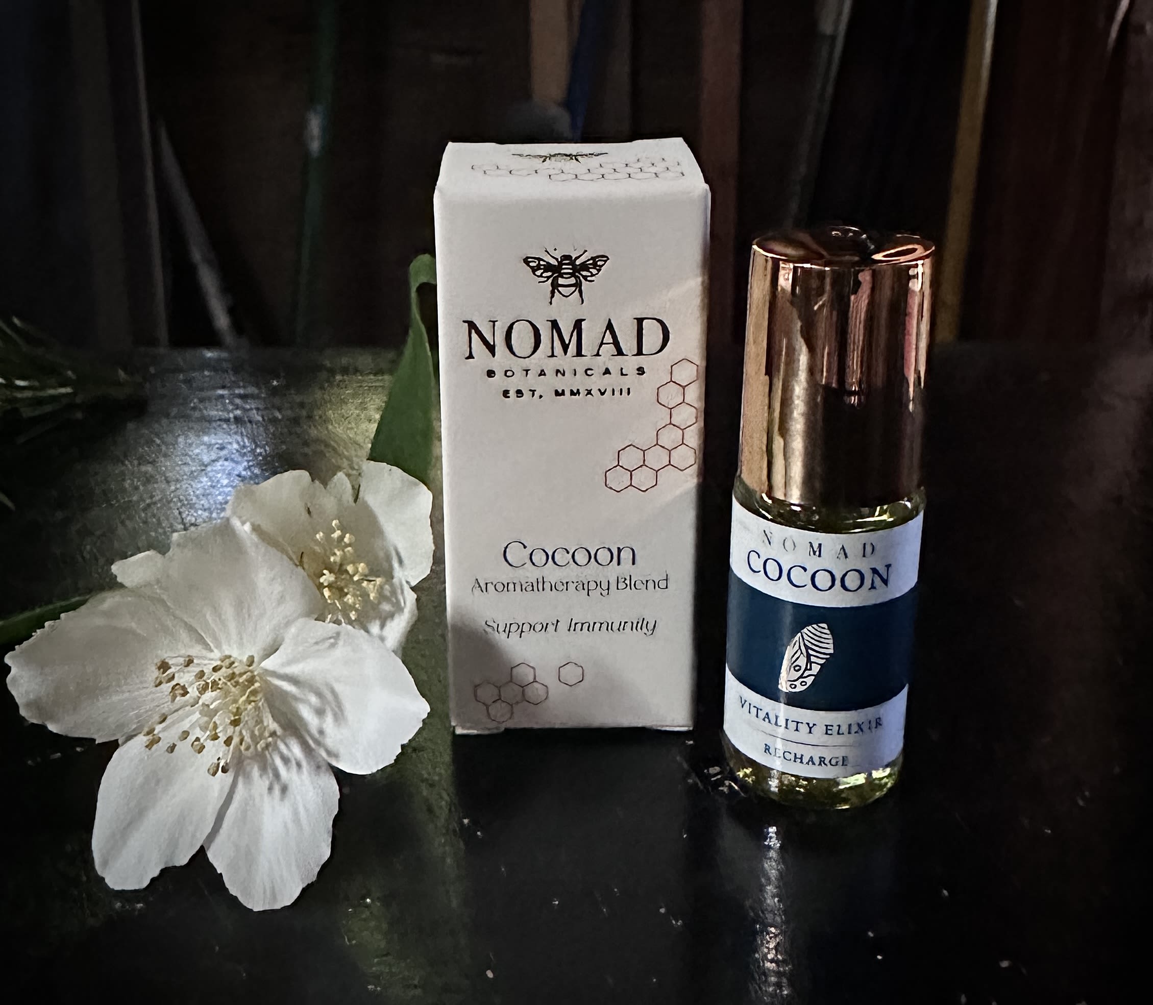 Cocoon Essential Oil Blend by Nomad Botanicals - Protects from the elements like a silken cocoon. Support your immune system as you roll on this revitalizing blend formulated with time-honored botanical allies. Recharge with this immune supporting aromatherapy blend. Jojoba Oil-golden*; Essential Oils of Sweet Orange*, Lavandin*, Black Spruce*, and Bay Laurel* (*organic) 5 mil Made in Petaluma CA