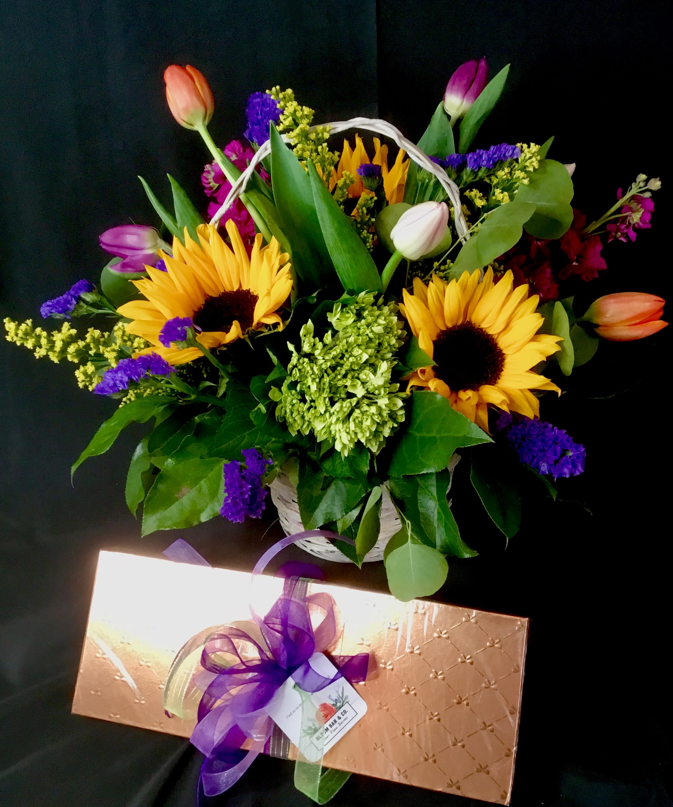 Basket of sunflowers and tulips with purple filler flowers