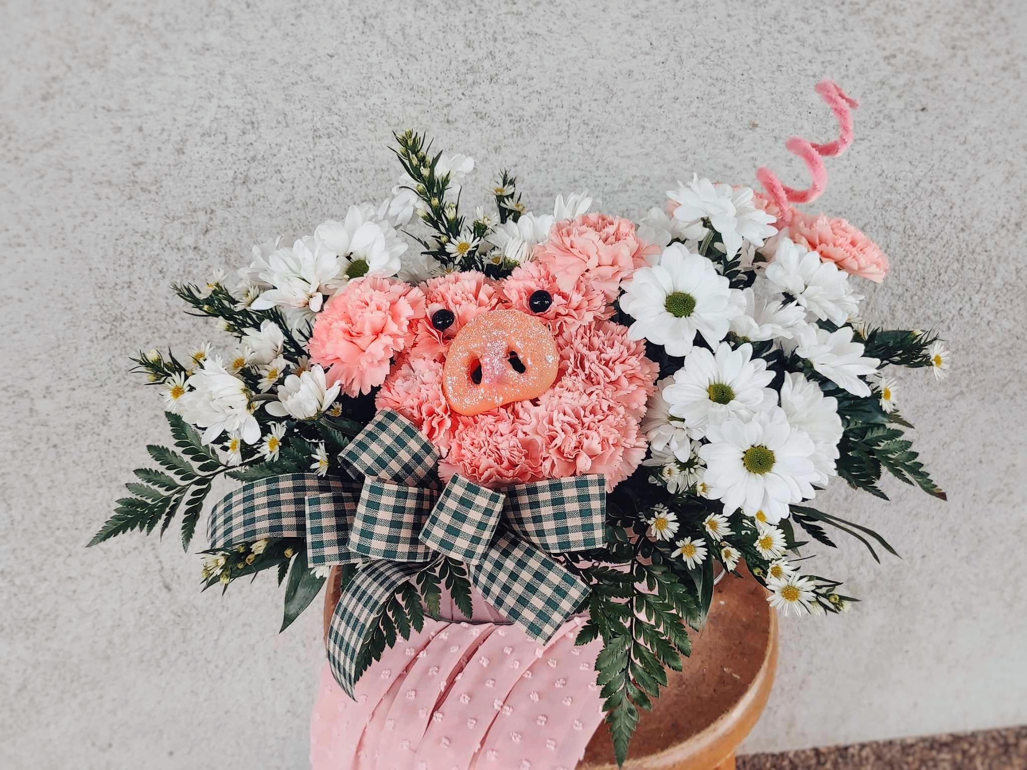 Pink floral arrangement with a pig face centerpiece and white daisies