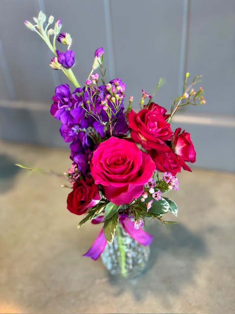 Bouquet of pink and purple roses in a glass vase