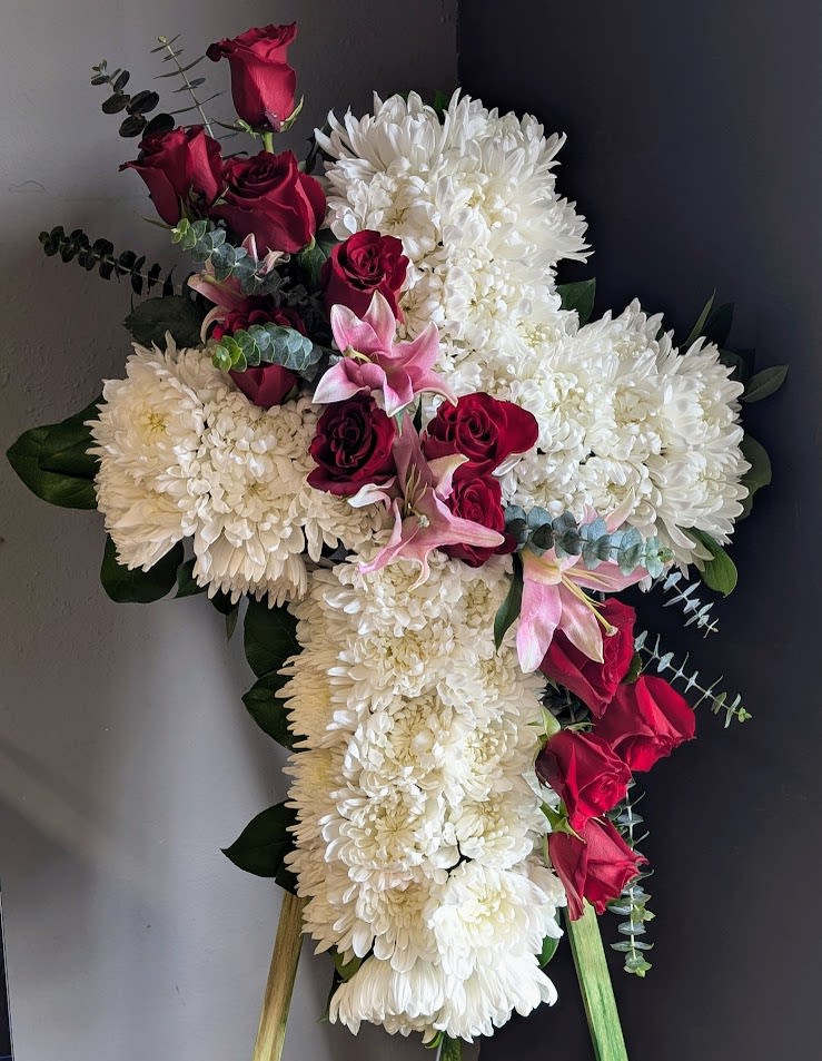 Cross-shaped floral spray with white chrysanthemums, red roses, and pink lilies